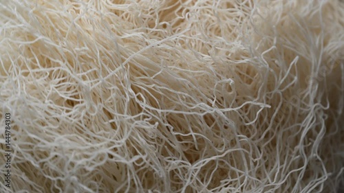 Delicate strands of kadaif are showcased in a lively kitchen, ready to be incorporated into a delicious traditional dessert. The warm lighting enhances the texture of the dough.