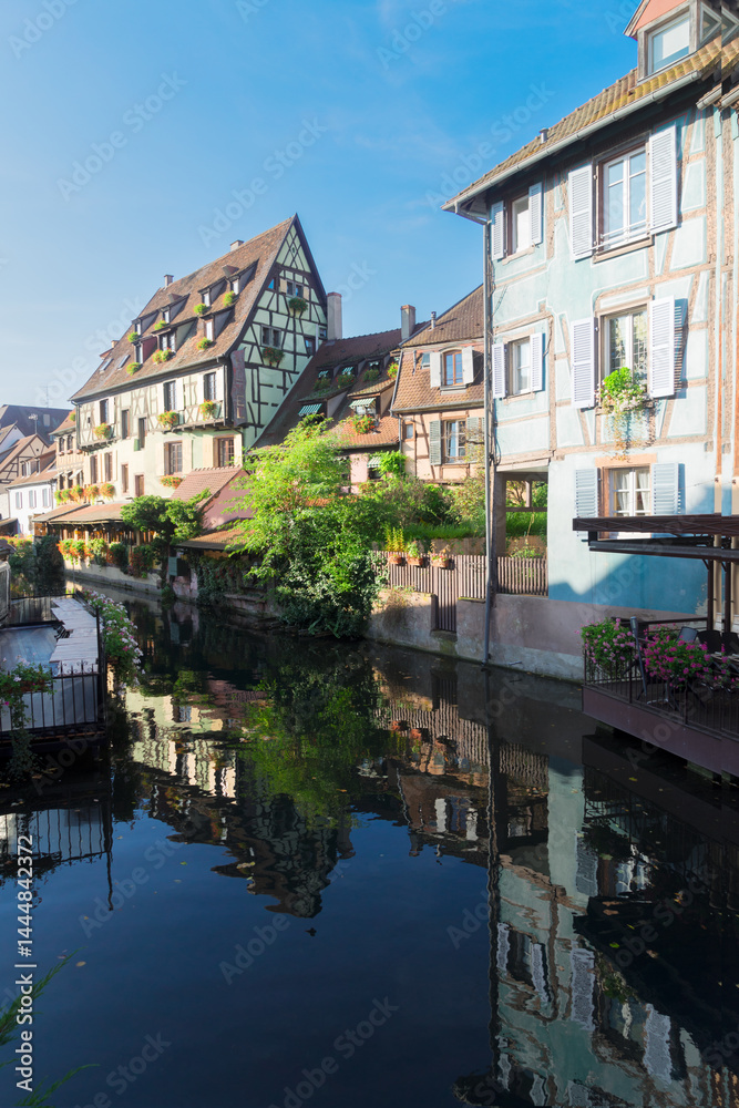 half timbered crooked houses of Colmar with reflections in water, Alsace, France