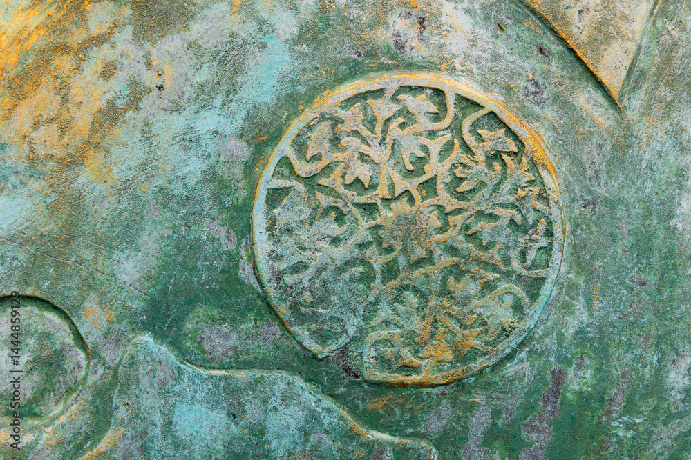 Weathered and textured surface featuring an intricate circular decoration