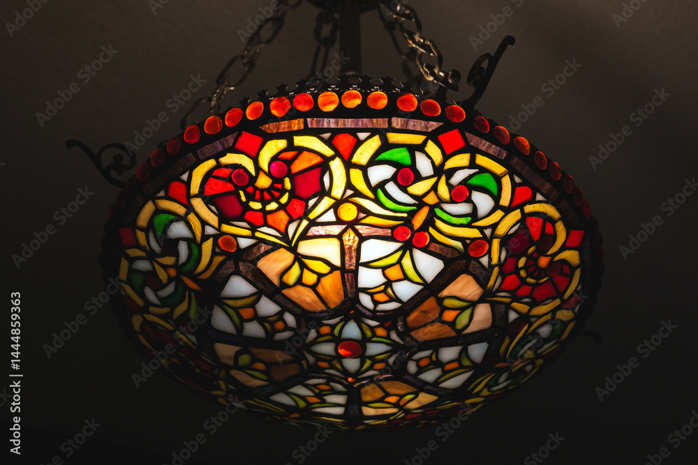 A vibrant close-up of a stained glass ceiling light featuring intricate patterns