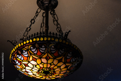 Obraz na płótnie Colorful stained glass chandelier with intricate patterns, casting warm light w salonie