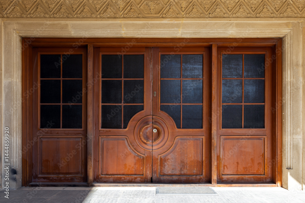 Beautiful wooden double doors featuring a symmetric geometric pattern
