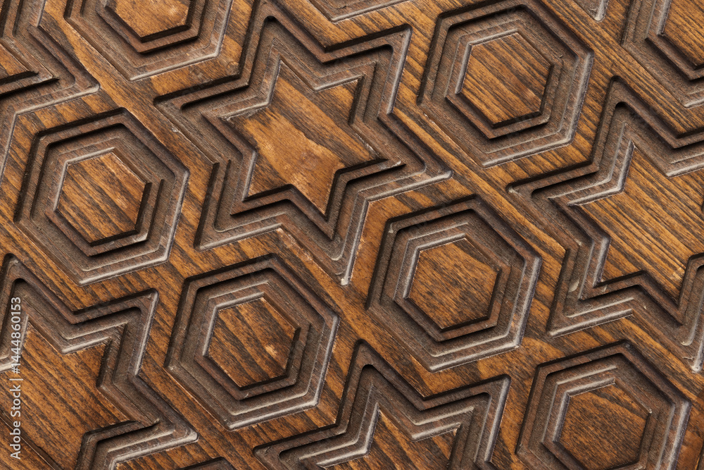 Carved wooden texture featuring geometric patterns of stars and hexagons