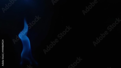Dancing with cerulean hues: an abstract blue flame in the dark background