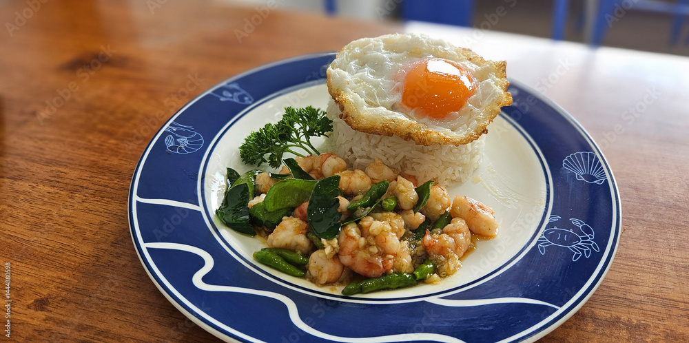 Stir fried prawn with bird’s eye chilies with streamed rice serving on blue plate