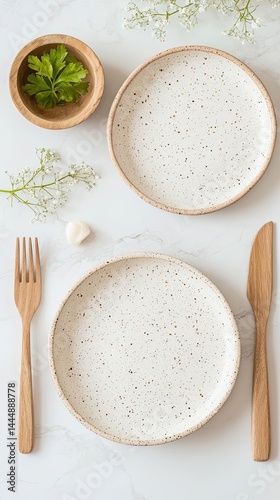Minimalist Table Setting with Speckled Plates and Wooden Cutlery