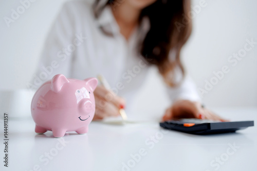 Planning personal finances with a piggy bank and calculator in a bright workspace