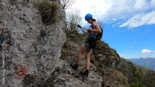 A determined hiker follows a slender path along the cresta, with sweeping views over Lecco’s lake and the distant Alps beyond.