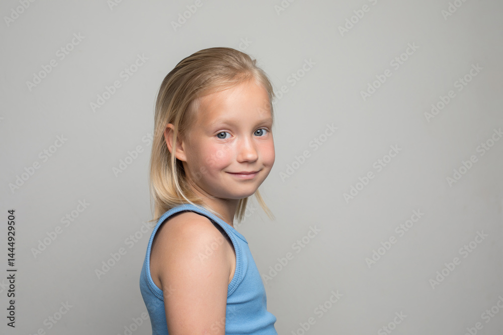 Naklejka premium Blond young child girl standing against white wall background