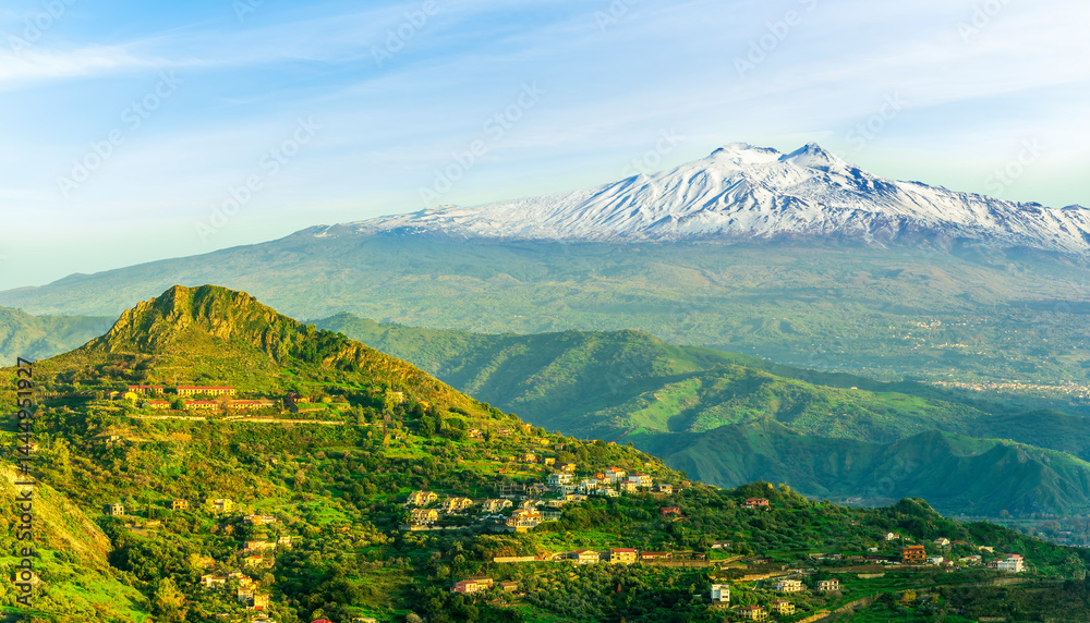 Fototapeta premium panoramic view of a national park with green mountains with palace and great white snowy top of a mountain on a blue cloudy sky background. Travel beautiful landscape of green hills. 