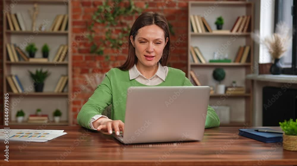 Focused Woman Working on Financial Calculations at Desk Focused Woman Working on Financial Calculations at Desk