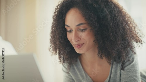 Wallpaper Mural Content African American woman leaning on hand while watching laptop screen with gentle smile. Engaging with video or browsing favorite website while staying cozy in soft loungewear at home. Torontodigital.ca