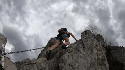 Chains guide the way up a steep slope where a climber plants each foot carefully on Cresta Giumenta’s rugged rock face.