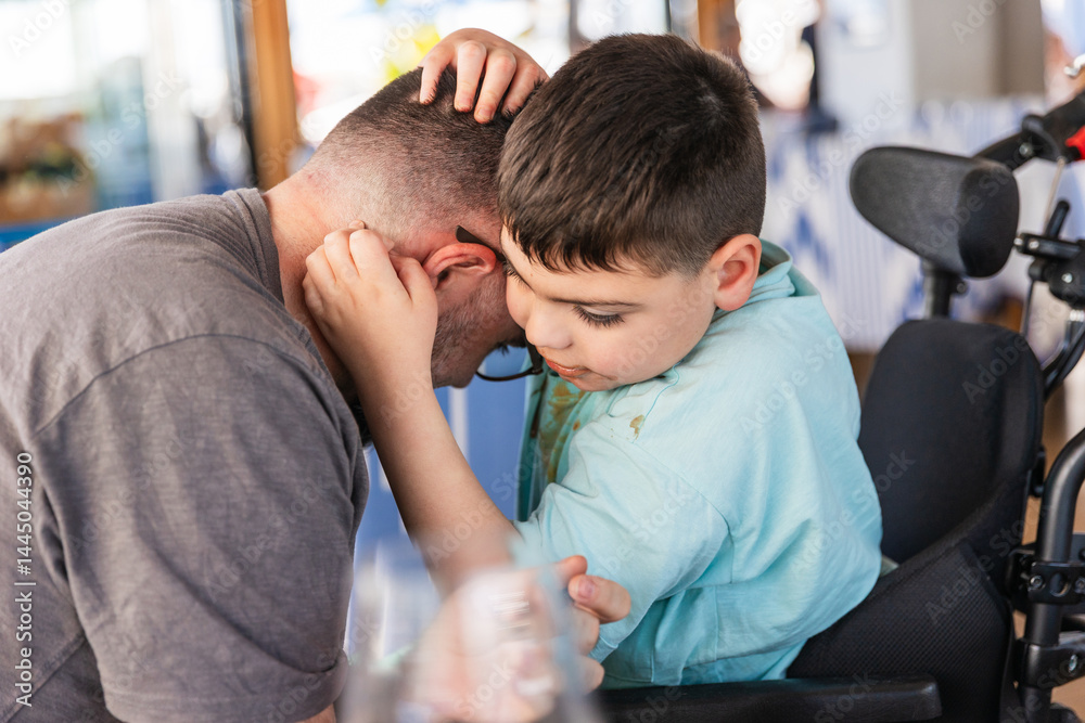 Disabled child showing affection to father during mealtime Disabled child showing affection to father during mealtime