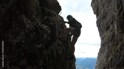 Rounding a rocky knob, a climber glimpses Lecco’s winding lakes below, clutching cables as the via ferrata demands full attention.