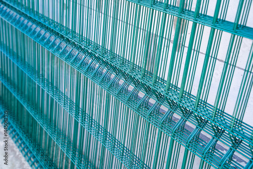 Welded mesh for fence in green color, several sections of transparent fence
