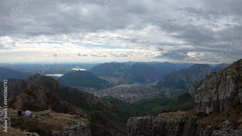 The final scramble leads to a grassy summit where Lecco’s winding waterways glisten far below beneath a clearing spring sky.