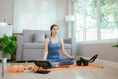 Confident young Asian woman practices yoga at home on exercise mat, embracing wellness, balance, and fitness through online training Free Download Confident young Asian woman practices yoga at home on exercise mat, embracing wellness, balance, and fitness through online training - GFXLoad