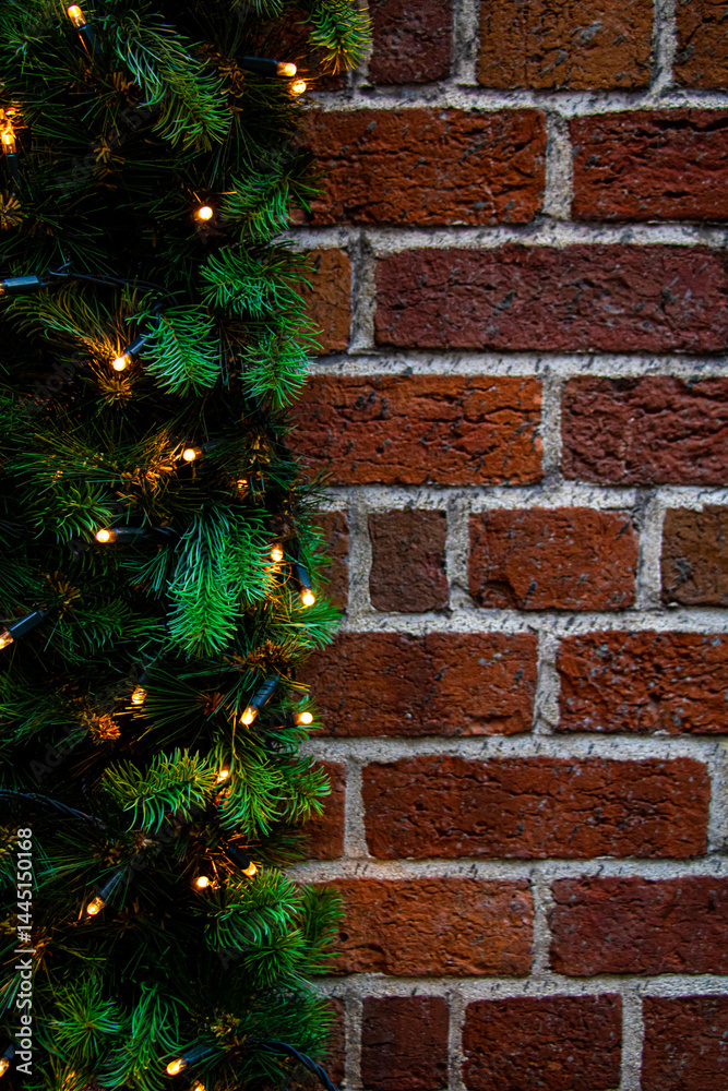 Vertical close-up shot of brick wall with garlands. Christmas background