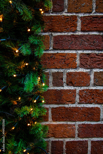 Vertical close-up shot of brick wall with garlands. Christmas background