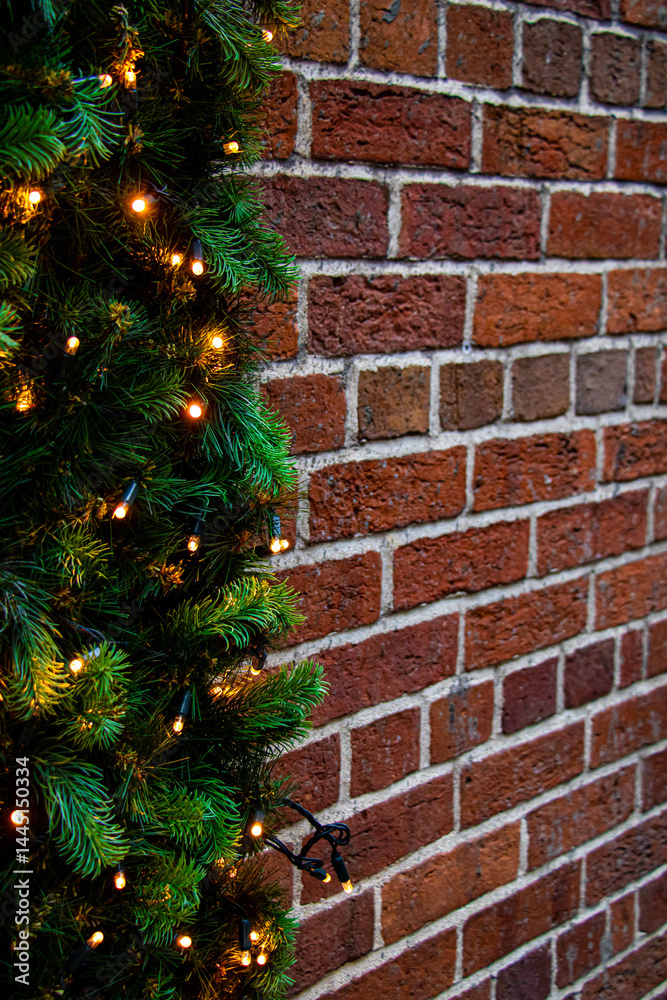 Side view on christmas garland with lanterns on brick wall, vertical shot
