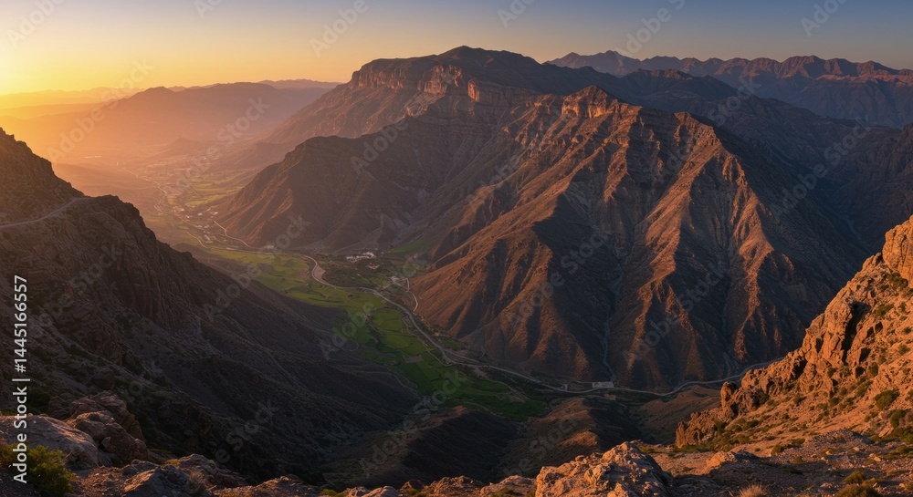 Fototapeta premium Sunrise Over Majestic Mountain Range with Green Valley in Arab