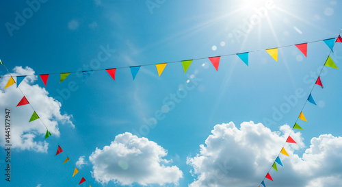 Colorful bunting flags adorning a bright summer sky filled with clouds