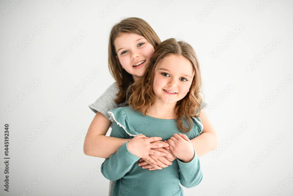 Portrait of two sisters of 6 and 8 years old over white background Portrait of two sisters of 6 and 8 years old over white background