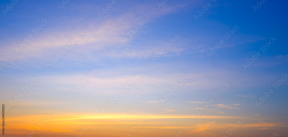 Fototapeta premium Sunset sky background with summer natural yellow golden light and cloud on blue panoramic evening sky backdrop