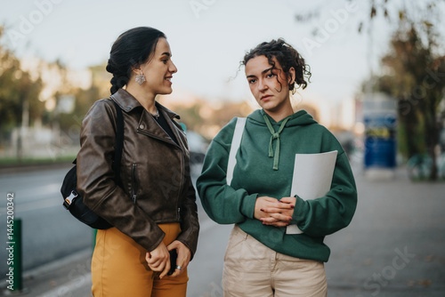 Foto Two women standing outdoors, one smiling with cheerfulness, the other appearing thoughtful