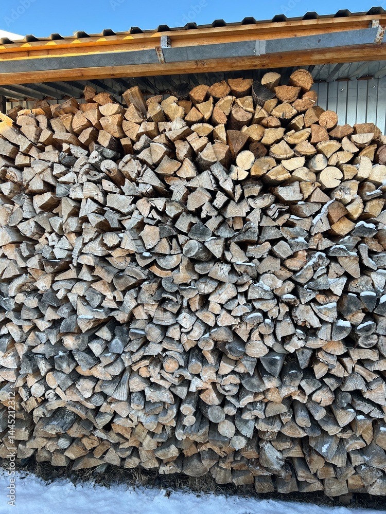 Firewood in the woodshed, preparation for the heating season in the village. Warm, brown colors, rustic style