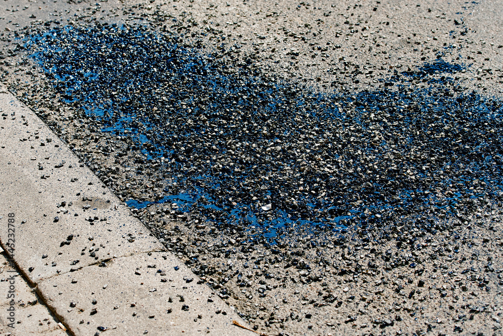 Asphalt crack sealing with bitumen, gravel and resin material during street repair, urban maintenance work for long-term road surface protection. Bitumen and gravel mix for repair asphalt road