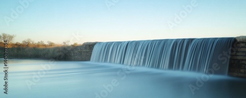 Peaceful waterfall cascading over a dam.