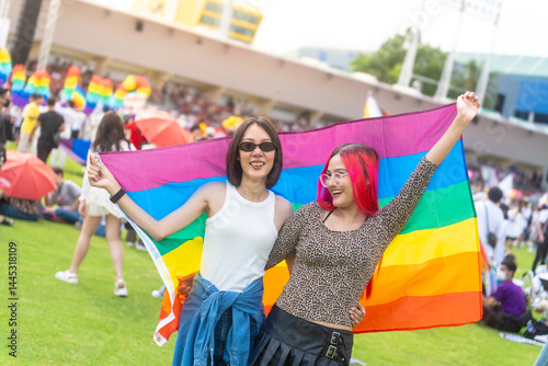 Photography Happy young asian lesbian couple with pride movement LGBT holding rainbow flag raise up for freedom