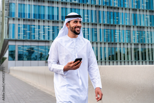 Arab middle-eastern man wearing emirati kandora traditional clothing in the city