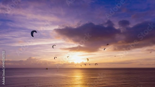 Colorful sunset over ocean with kitesurfing.