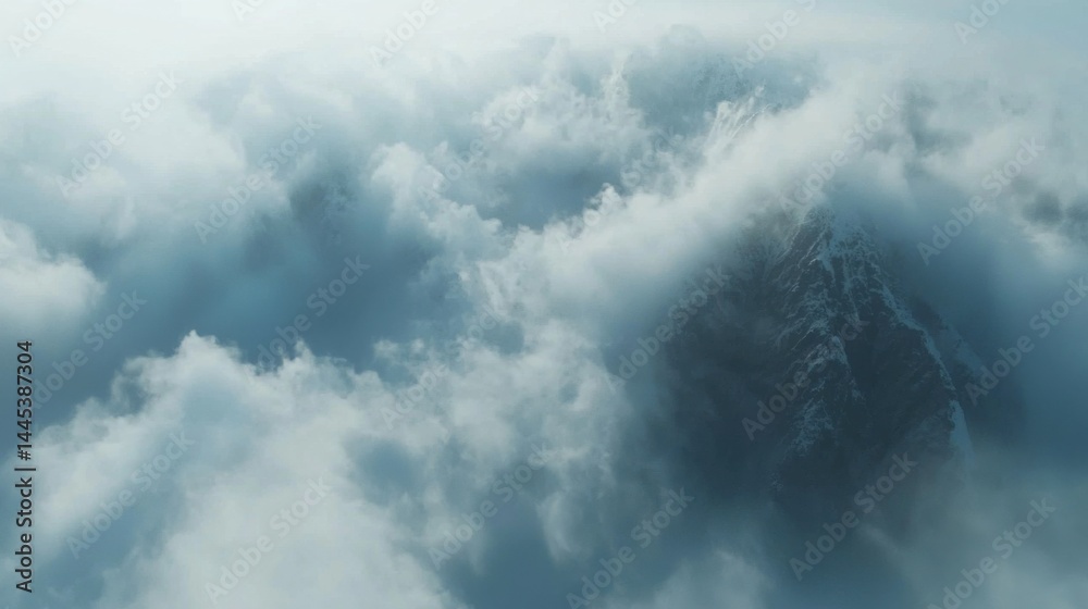 Fototapeta premium Majestic mountain peak surrounded by dense storm clouds du a turbulent weather scene in a high-altitude environment with dramatic sky and natural landscape