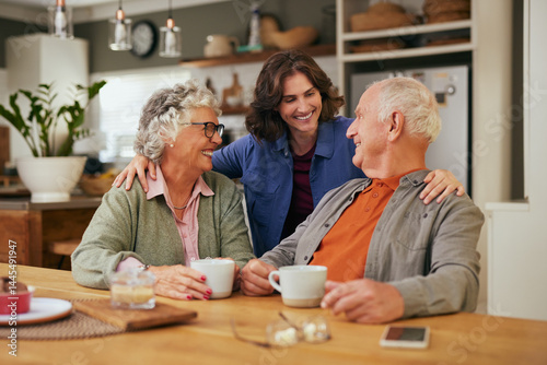 Happy smiling senior parents with adult daughter drinking tea photo