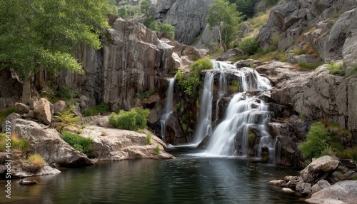 The waterfall cascades gracefully over the rugged rocks, creating a mesmerizing view
