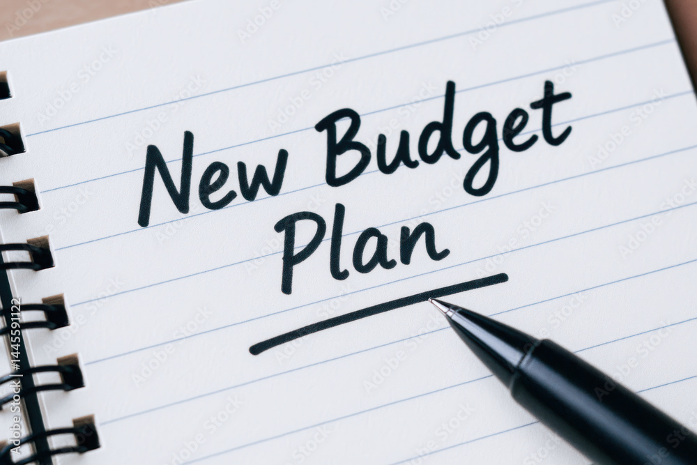 New budget plan written on notebook with pen nearby symbolizing financial planning to avoid debt and eviction notice for better money management