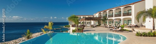 Resort hotel with swimming pool overlooking ocean and clear blue sky