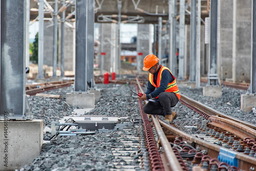 Engineer Inspecting Railway Track During Construction