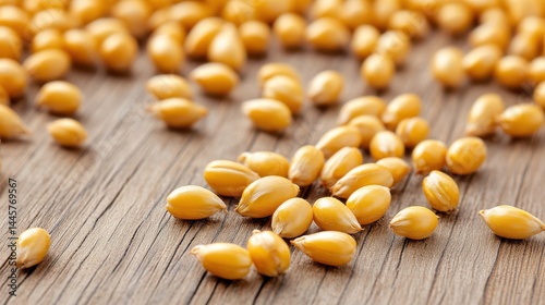 A close-up shot of individual barleycorns scattered across a rustic wooden surface, showcasing their natural texture and golden hues.