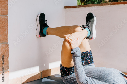 Close-up of woman doing figure 4 stretch for post-run recovery