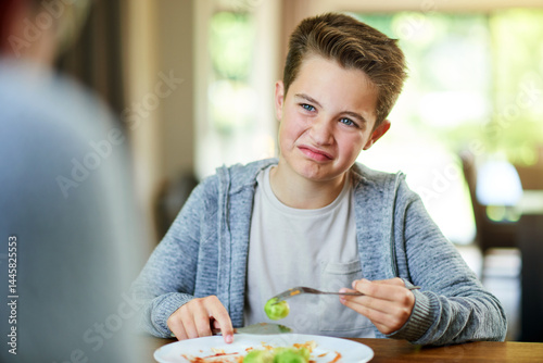 Upset, child and reject food at dinner table for eating vegetables and no to nutrition at home. Healthy, brussel sprout and face with disgust, refuse and fussy eater with balanced diet and salad
