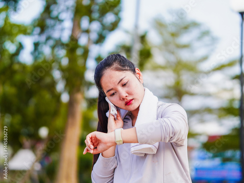 Wallpaper Mural Asian fitness woman looking smartwatch data tracking exercise in nature park holiday. Motivation energy activity workout and healthcare. Wellness Lifestyle female of Southeast Asia work life balance  Torontodigital.ca