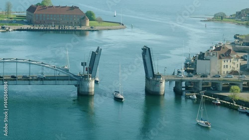 Boats Passing Through the Open Bascule Bridge into the Harbor of Sønderborg, Denmark, Seen from Above on a Sunny Day with Blue Water, Clear Sky, and Coastal Vibes photo
