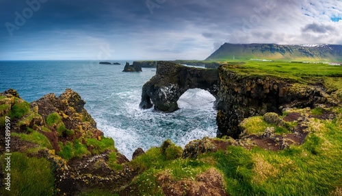 iceland arnarstapi dramatic coastal cliffs in iceland with steep drop to the ocean green grass covered plateau meets vertical rock face with crashing waves below