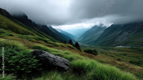Lush Green Mountain Valley Under Cloudy Sky with Rolling Hills and Misty Mountains
