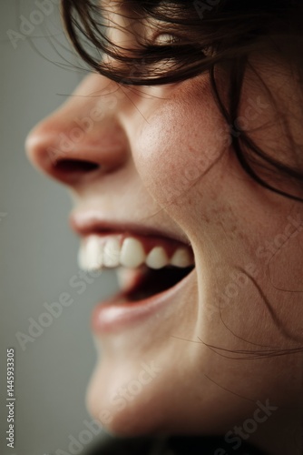 Close-up shot of a woman smiling widely, capturing the joy of the moment with visible teeth.